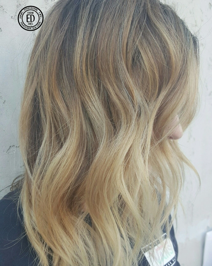 Woman with sun-kissed babylights and tousled beach waves enhancing her hair texture