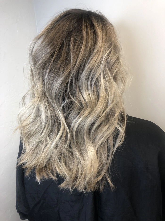 Model showcasing balayage beach wave styling with sun-kissed, effortless waves