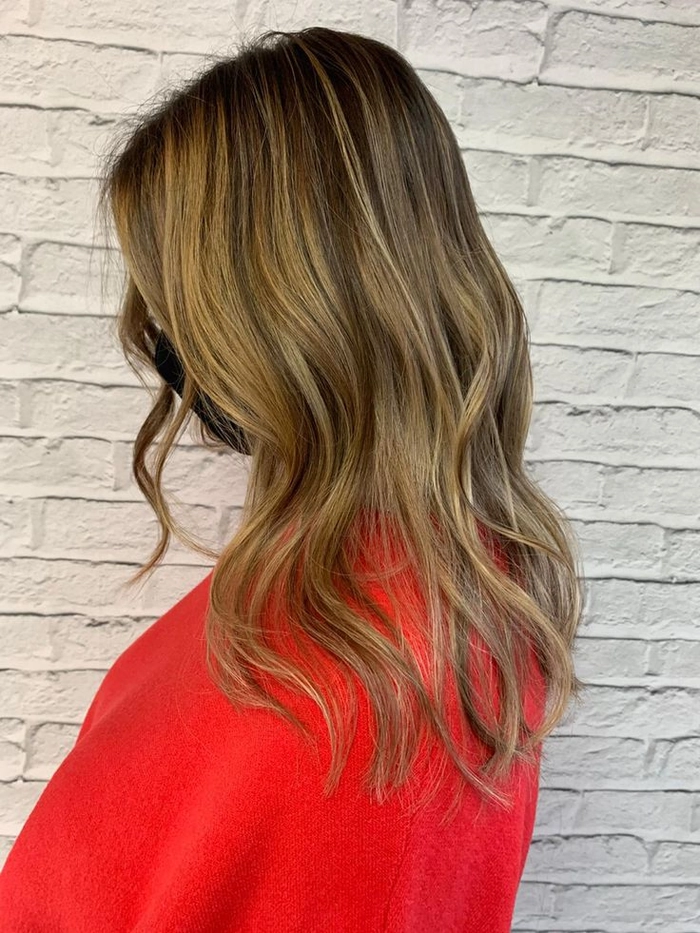 Woman with sun-kissed balayage beach waves styled on the sand
