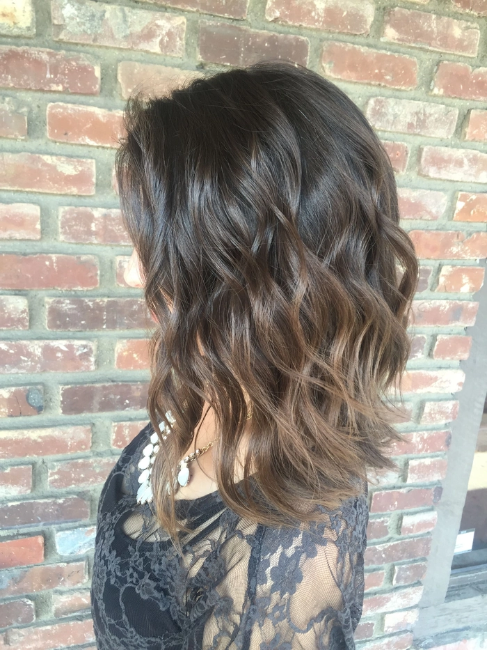 Woman with sun-kissed balayage hair styled into loose beach waves
