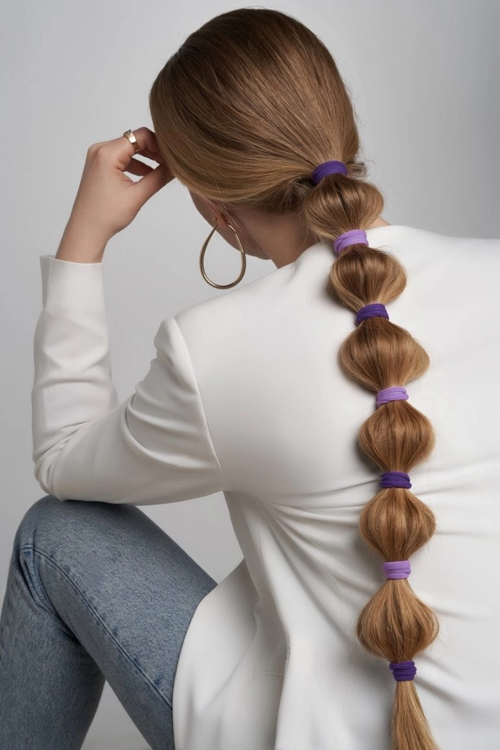 Close up of a beach bubble ponytail with loose waves and a fabric scrunchie