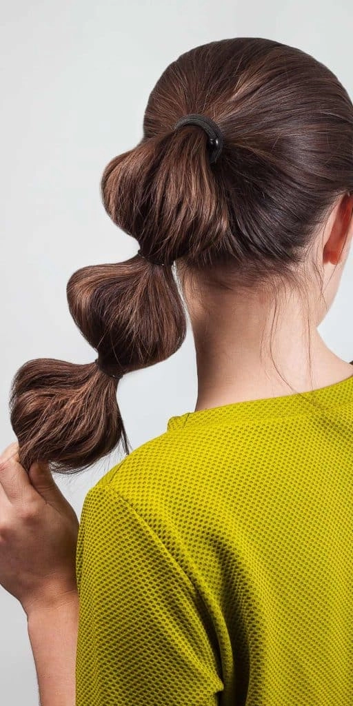 A beach bubble ponytail hairstyle with multiple sections and soft waves
