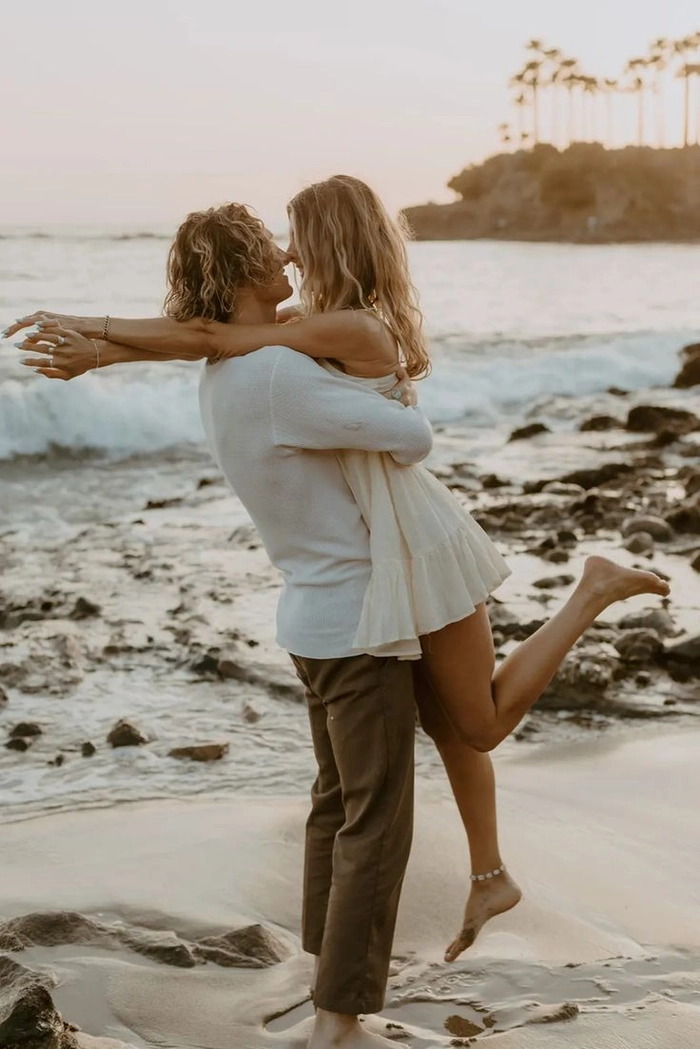 Beach engagement session hair trends - image 2 with loose waves and natural texture Beach engagement hairstyle featuring soft, windswept waves and delicate floral accents