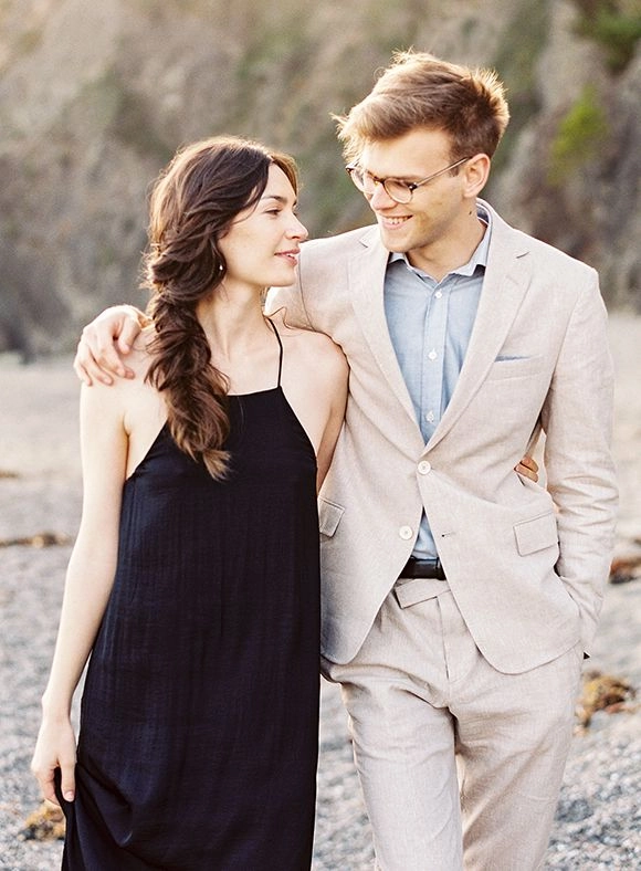 Beach engagement session featuring soft, windswept hair trends with natural waves Bride with flowing beach waves during romantic engagement session on sandy shore