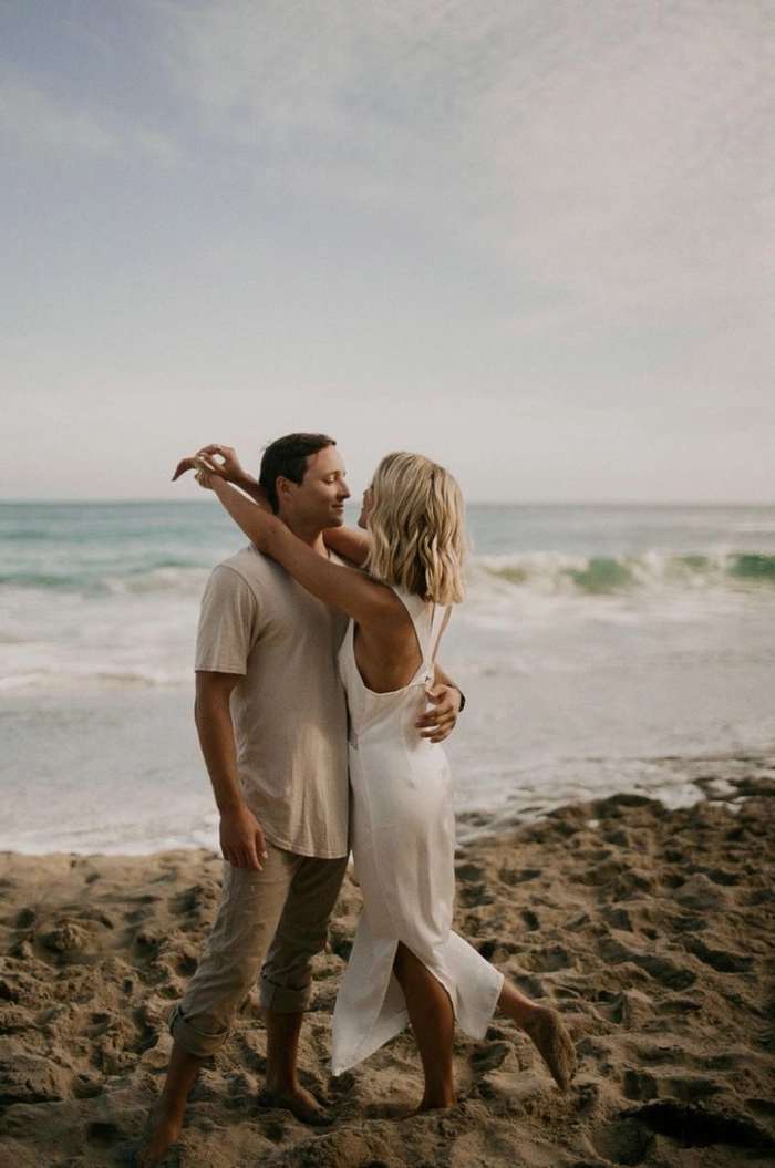 Trendy Beach Engagement Hair: Loose Waves with a Seaside Touch Beach engagement hairstyle with soft, windswept waves and delicate florals