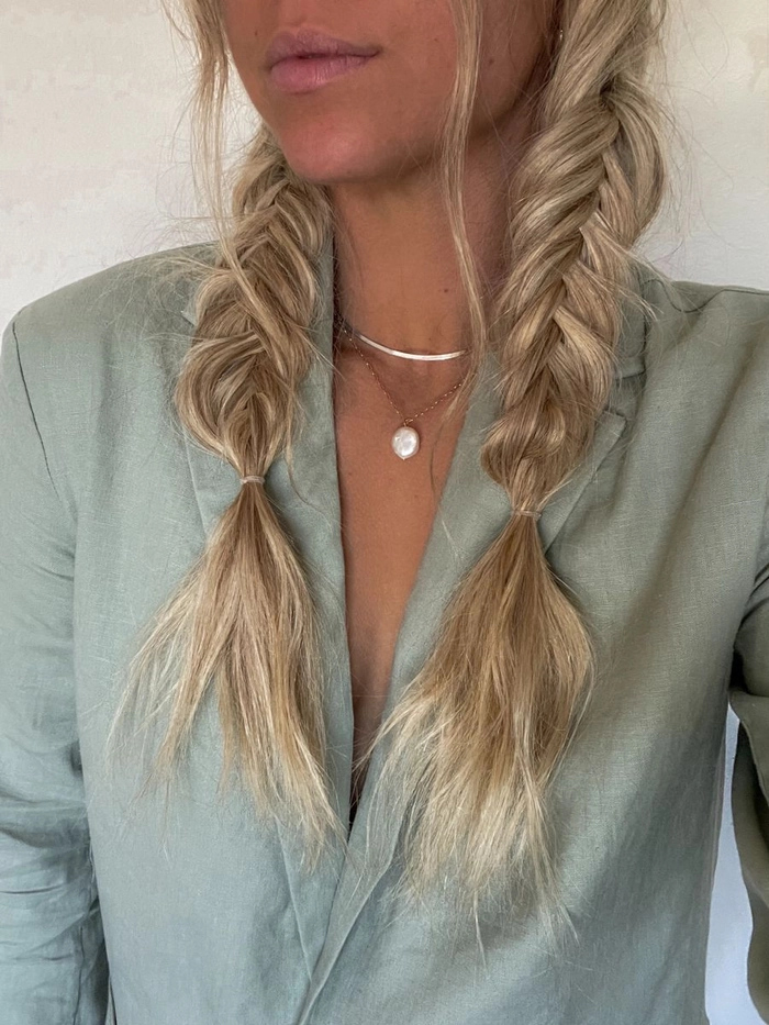Woman with a loose beach fishtail braid adorned with small seashell clips