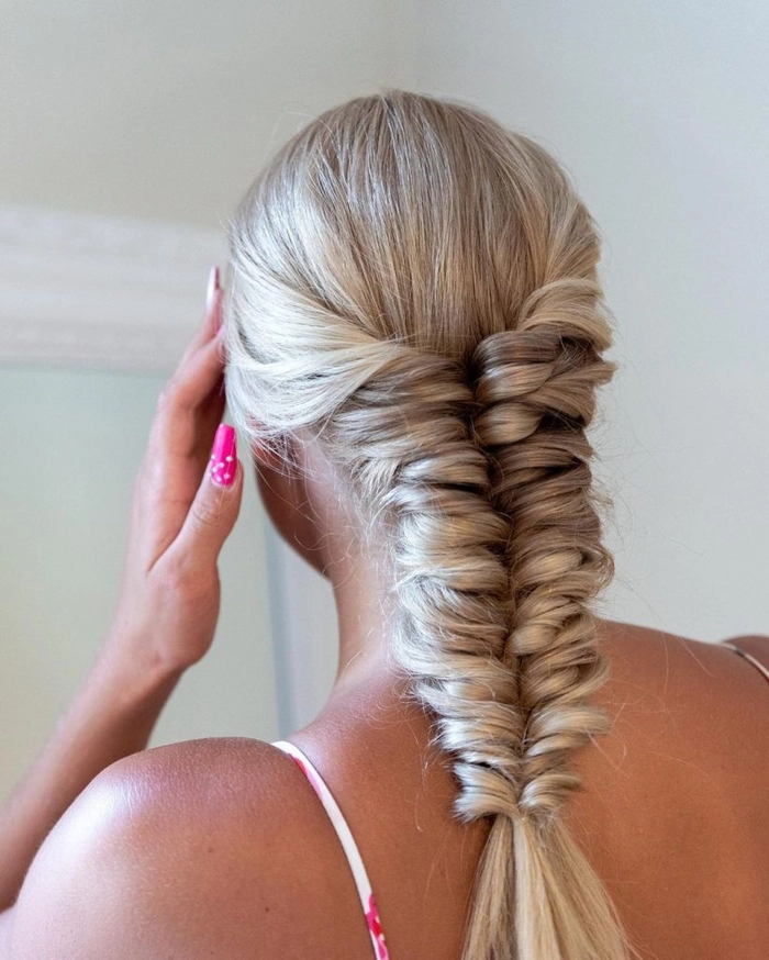 Woman with a beachy fishtail braid variation featuring loose waves and sea salt texture