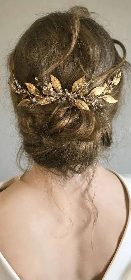 Elegant beach hair featuring delicate gold leaf details Beach hairstyle with gold leaf accents blowing in the sea breeze