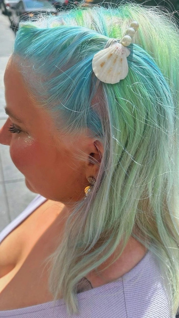 Gold leaf beach hair design for a tropical summer look Beach hairstyle with delicate gold leaf accents woven through windswept waves