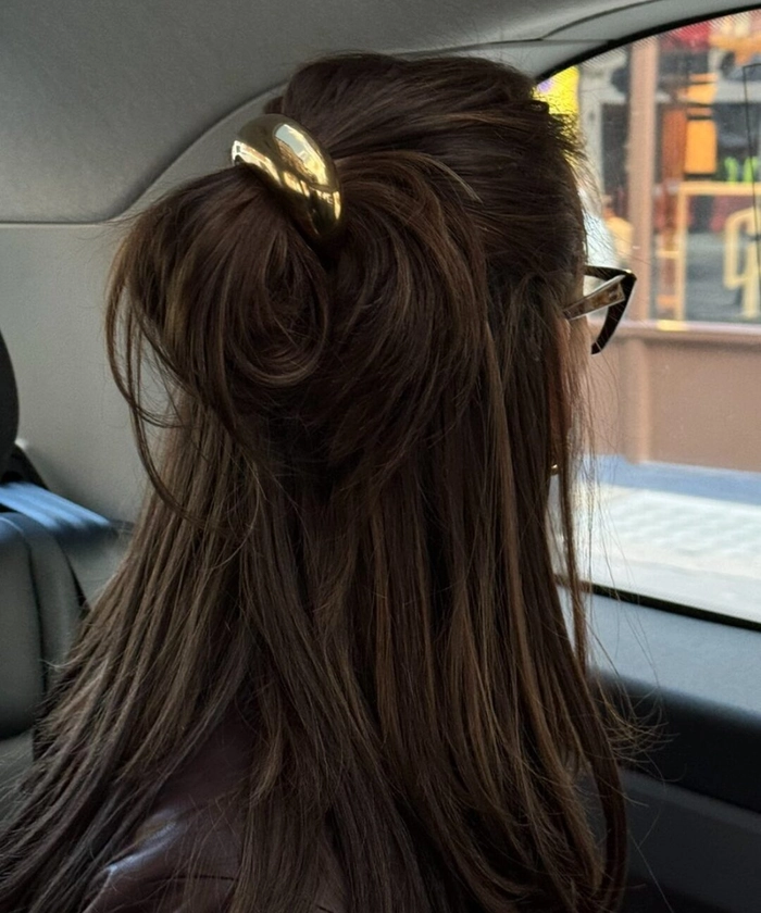 Beach hairstyle featuring sleek metal cuffs for a relaxed seaside boho look Woman with sun-kissed beach waves and minimalist metal cuffs woven into her hair