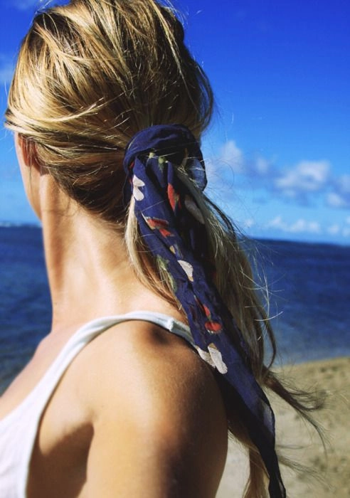 Beach Hair with Silk Scarves Style 3: Effortless seaside elegance with a colorful scarf Woman with tousled beach waves and a silk scarf wrapped elegantly around her hair