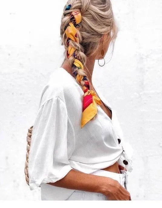 Effortless beach hairstyle featuring a silk scarf Beach hair styled with a vibrant silk scarf