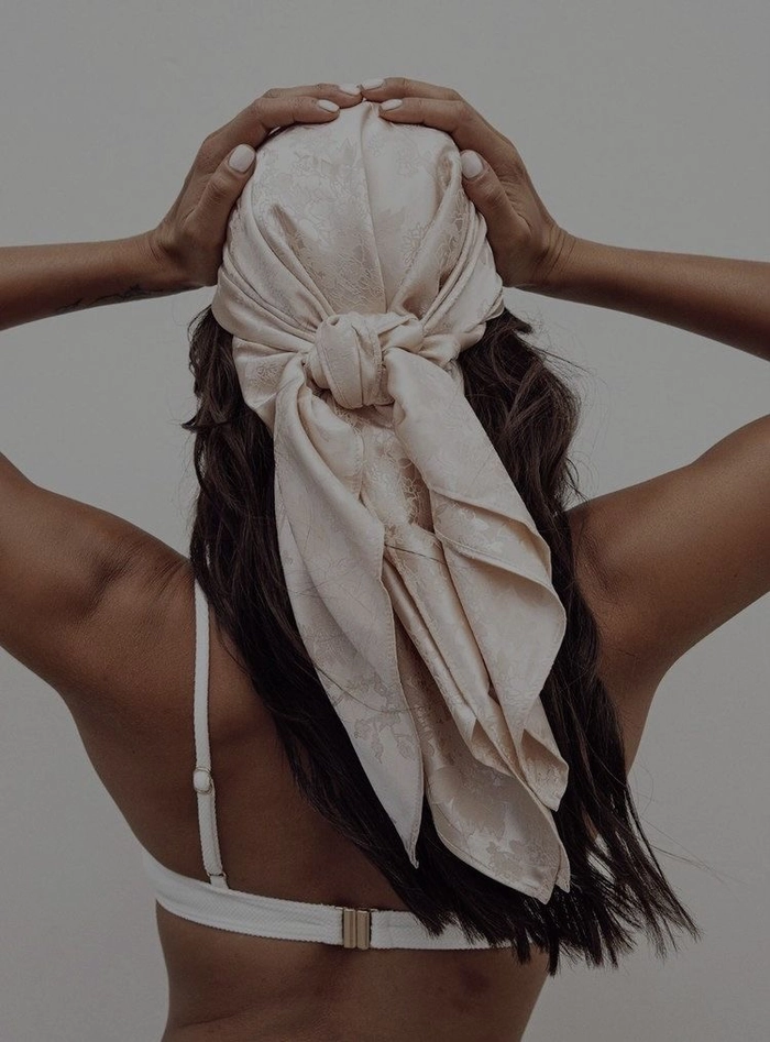 Beach hair styling with silk scarves for effortless summer waves Flowing beach hair wrapped with a silk scarf for a stylish seaside look