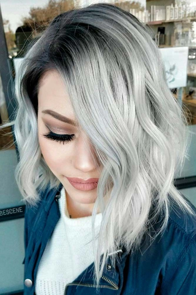 Silver-haired woman with tousled beach waves and a soft ocean breeze