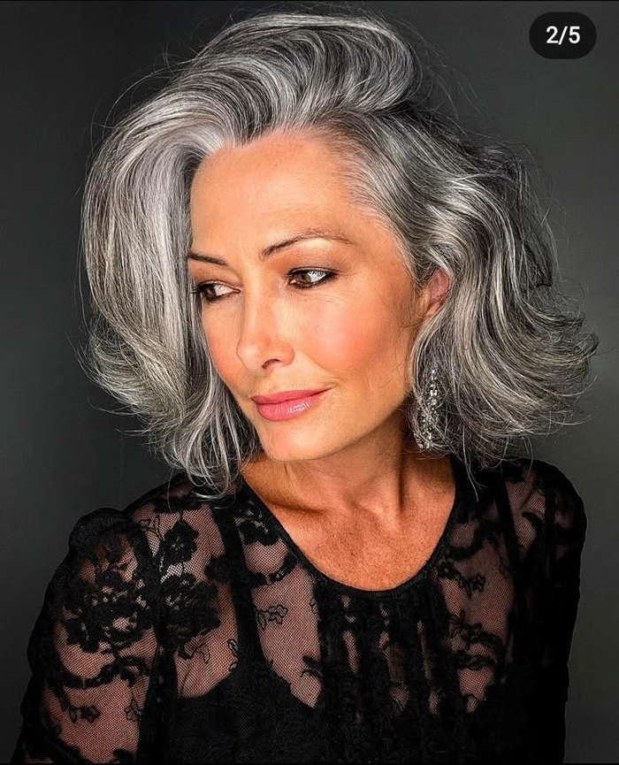 Woman with flowing silver and gray beach waves at the shore