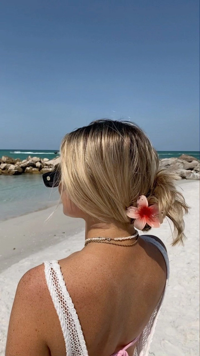 Woman with beach waves and fresh tropical flowers in her hair