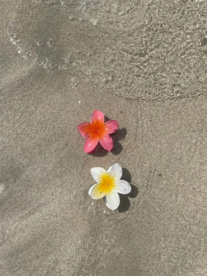 Woman with beachy waves and fresh tropical flowers woven through her hair
