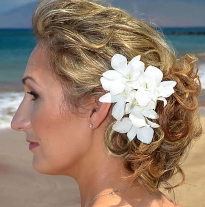 beach hairstyle with fresh tropical flowers woven into braided hair