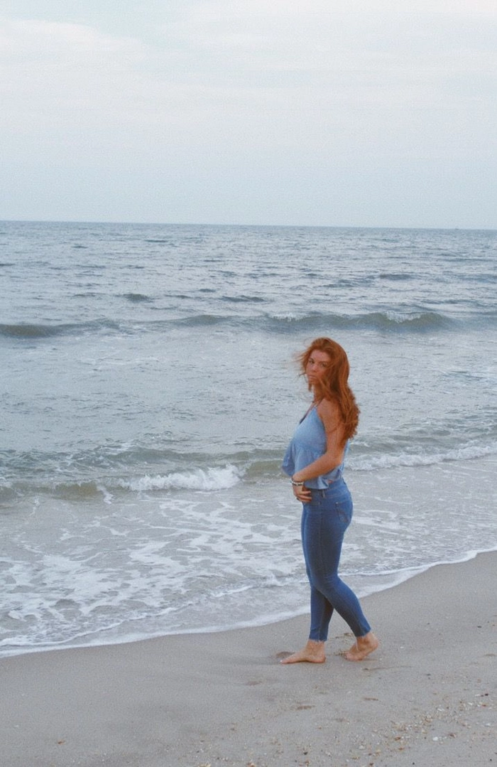 Redhead woman with tousled beach waves and sun-kissed highlights
