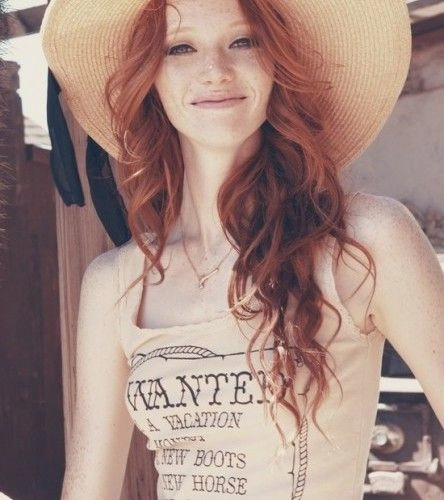 Beach waves and tousled hair on a redhead with sun-kissed highlights at the shore
