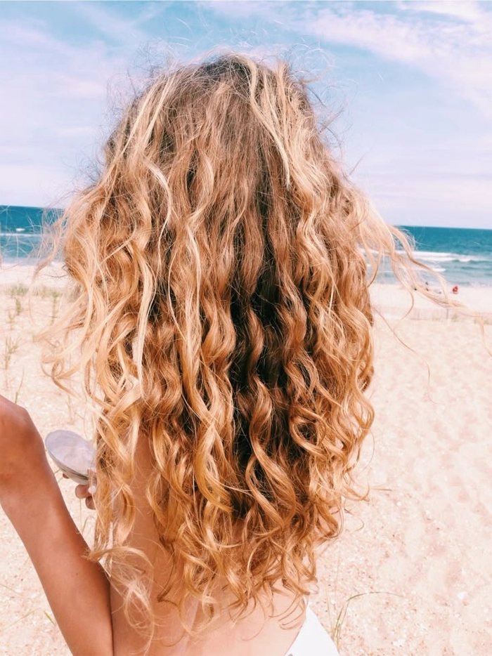 Woman with naturally curly beach waves styled with messy texture and soft frizz