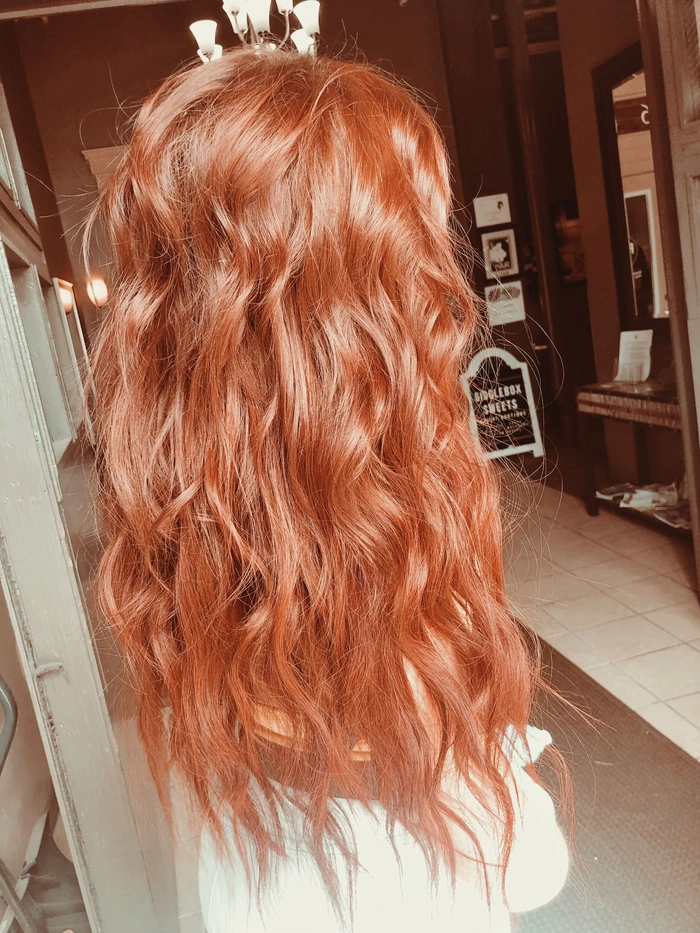 Redhead woman with tousled beach waves and sun-kissed copper highlights