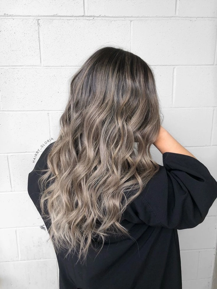 Woman with silver gray hair styled in beachy waves at the shore