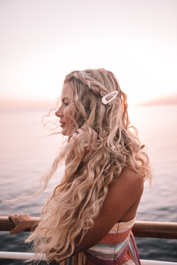 Woman with windswept beach hair posing in sunglasses
