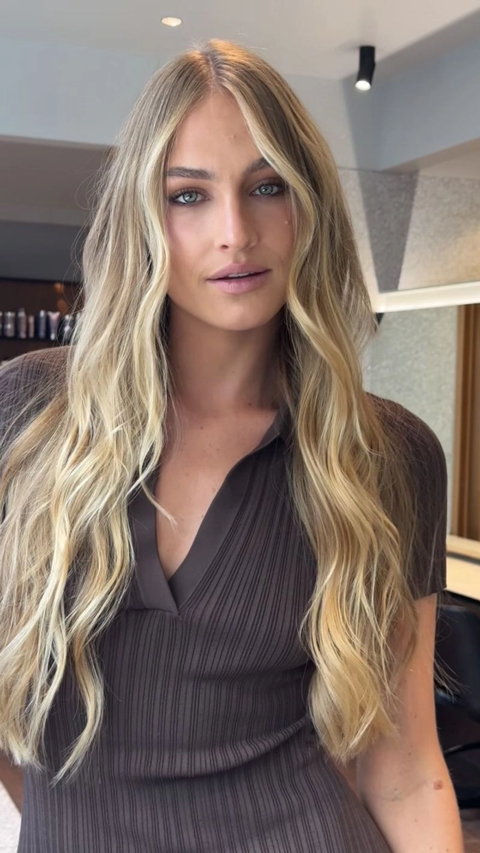 Effortless beach hairstyle for women over 40 with gentle curls Woman over 40 with tousled beach waves and a soft smile at the shoreline