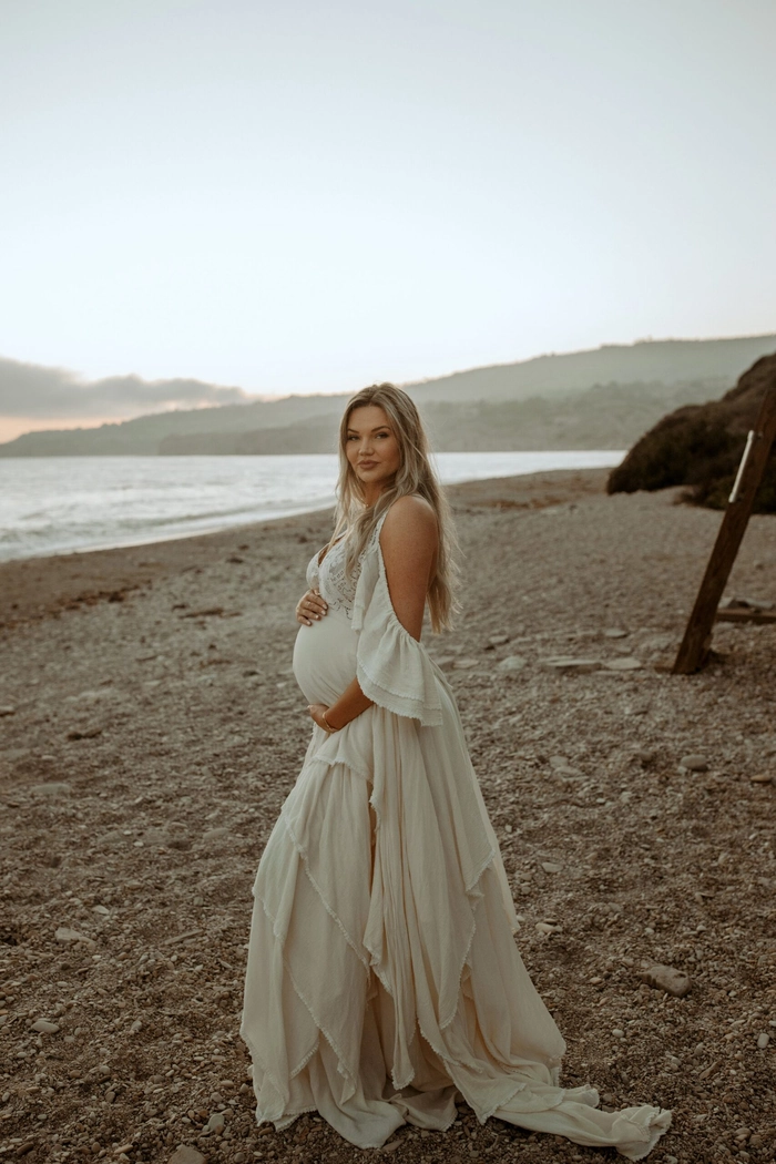 Beach Maternity Hair Inspiration for a Stunning Photoshoot Flowing beach maternity session hair styled with soft waves and a floral accessory