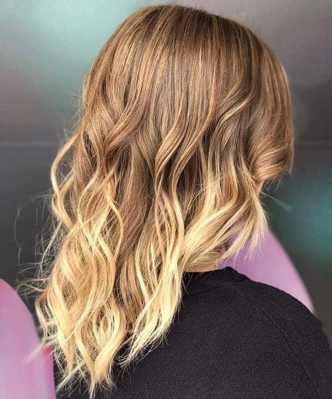 Woman with medium length hair styled in loose beachy waves