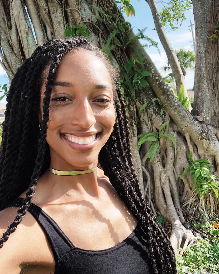 Coily hair beach protective style with twisted buns and seashell decorations Protective beach style for coily hair with twisted buns and seashell accessories