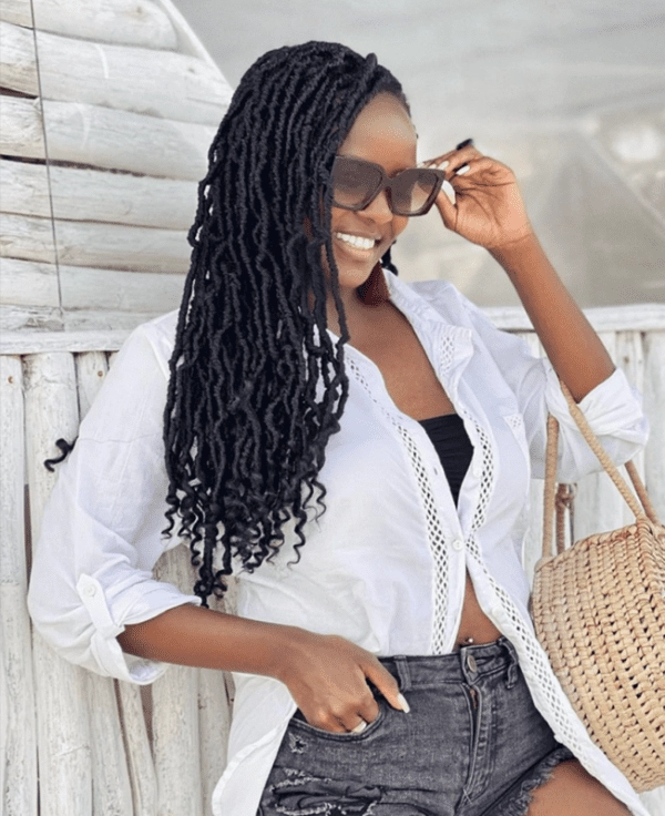 Coily Hair Beach Protective Style 10 - Elegant Twist Updo for Seaside Days Woman with coily hair styled in a beach protective updo with twists and accessories