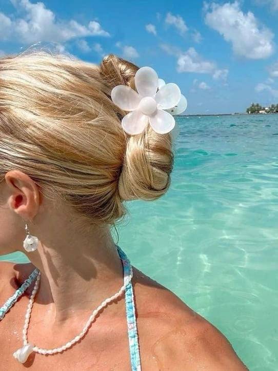 Beachy spring break hairstyle for college students College student with beachy waves and sunglasses on spring break sand
