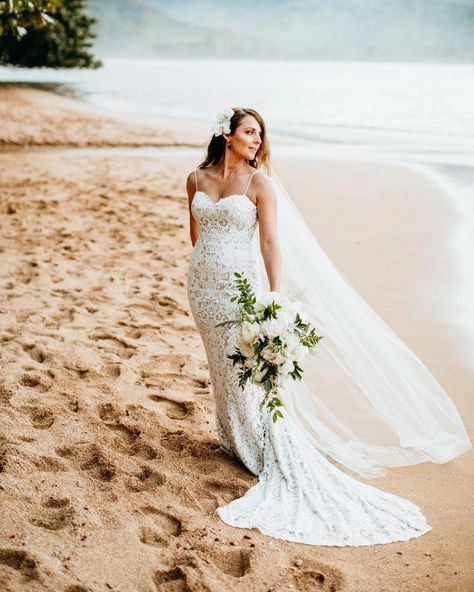 Bride wearing an effortless beach-inspired updo with sea salt texture and tropical flowers Elegant beach wedding hairstyle for destination bride with soft waves and floral accents