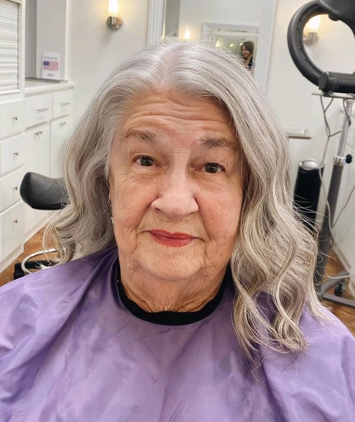 Older woman with elegant silver beach waves and a relaxed smile