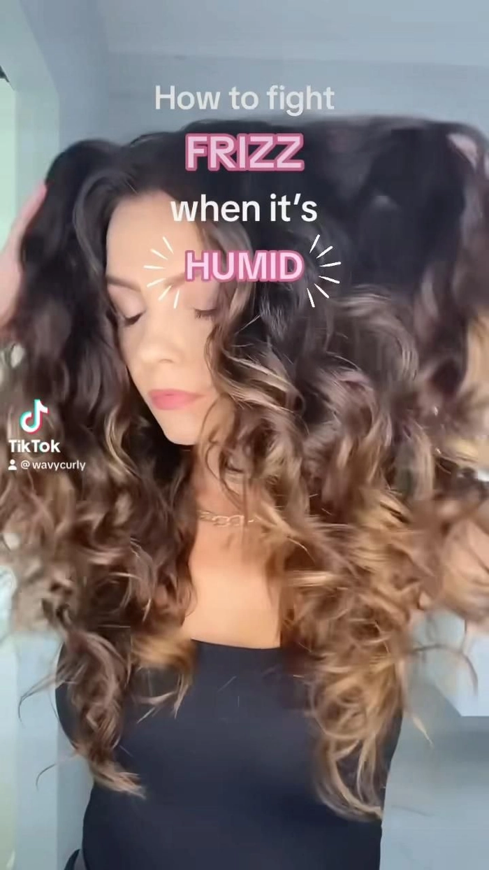 5 Tips for Preventing Frizzy Hair from Beach Humidity Woman applying anti-frizz hair product on beach with ocean waves in background