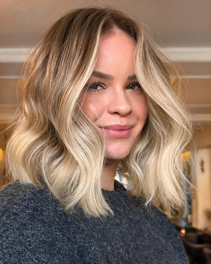 Woman with long glamorous beach wave hairstyle and golden highlights