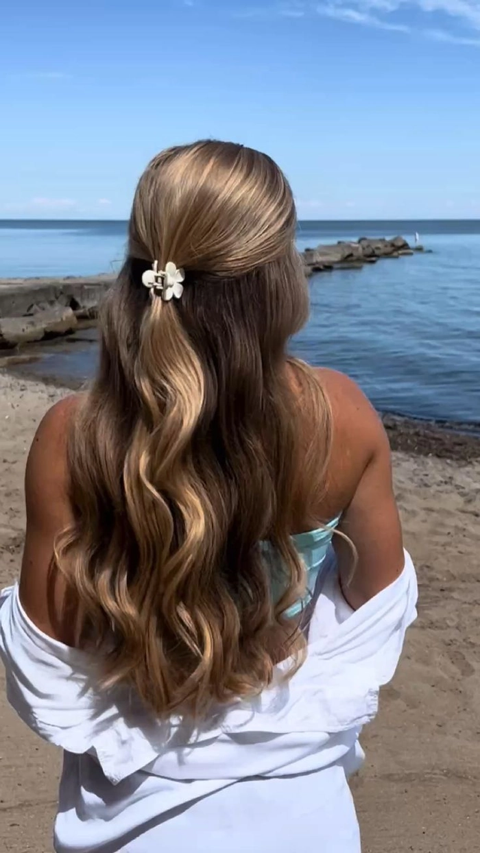 Glamorous beach waves cascading over one shoulder, with soft golden highlights catching the sunlight