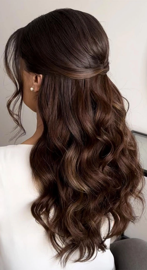 Effortless half up half down beach hair with a touch of boho flair Half up half down beach hairstyle with soft waves and a small braid