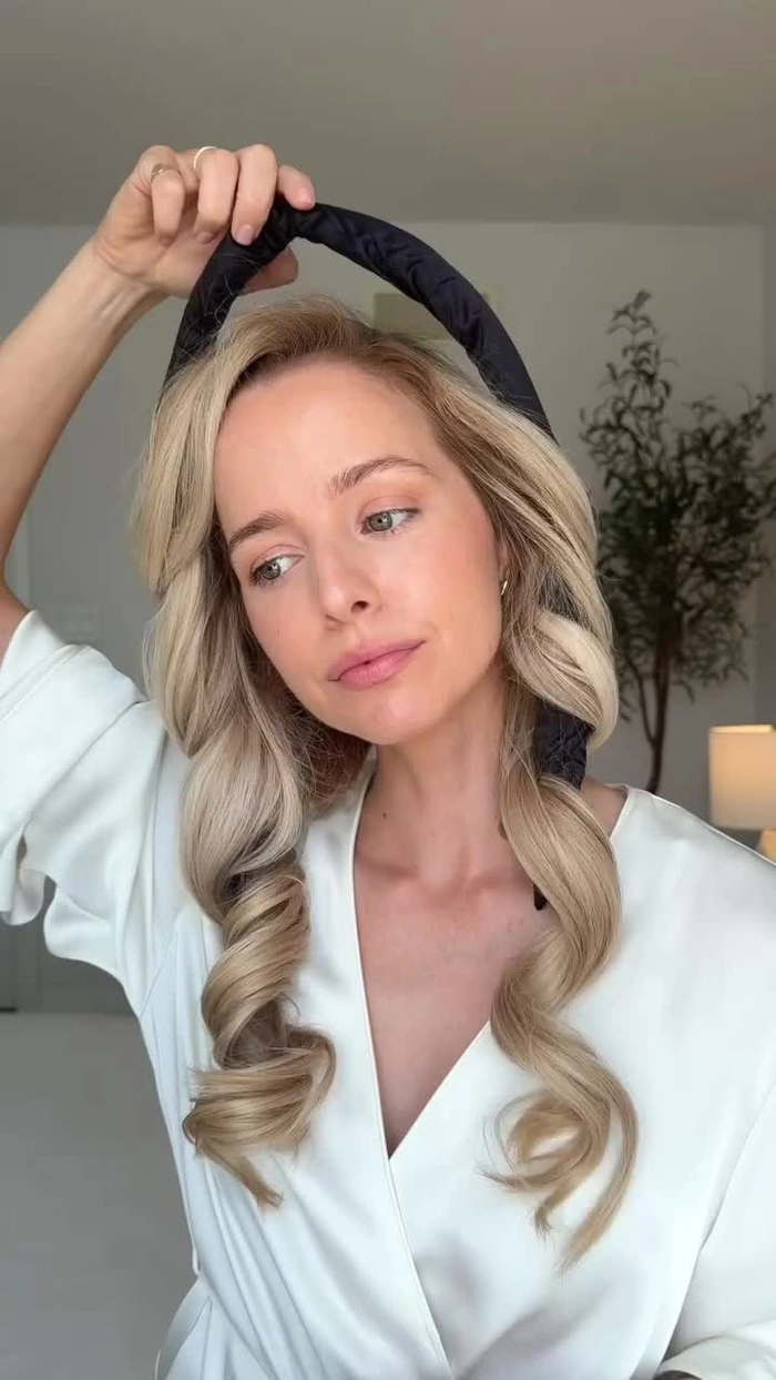 Heatless beach curls achieved with overnight braiding technique Woman with soft beach waves from heatless braid method