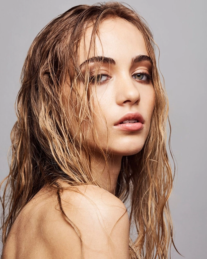 Woman with sleek wet hair styled in beach waves with glossy shine