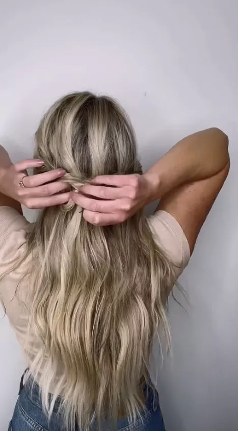 Easy five-minute beach bun hairstyle hack Woman tying a quick beach bun in under five minutes