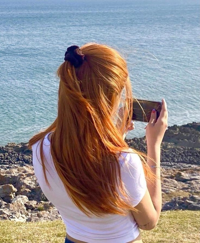 Redhead woman with tousled beach waves and soft highlights