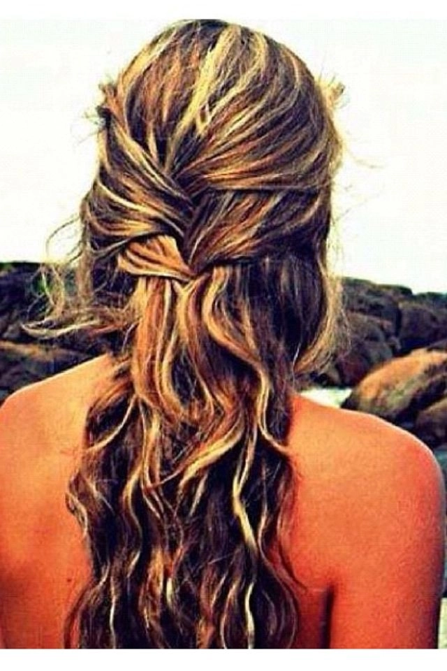 Effortless half up half down beach hair style for a day at the shore A woman with a relaxed half up half down beach hairstyle, waves and a sun-kissed look
