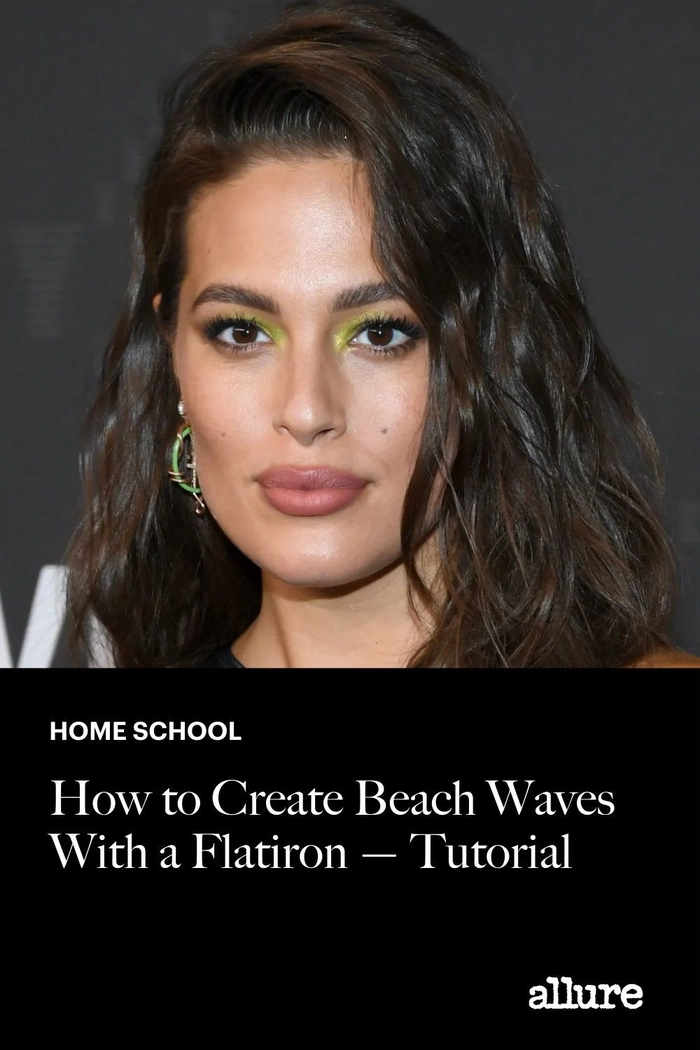 Woman styling her hair with a flat iron to form loose beach waves