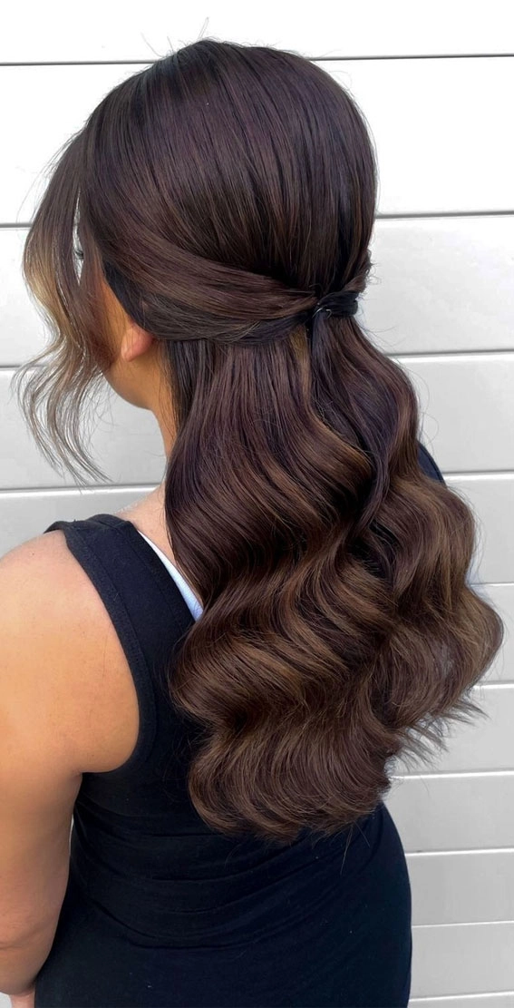 Beachy half up half down hairstyle perfect for warm weather days Half up half down beach hair with soft waves and a braided crown