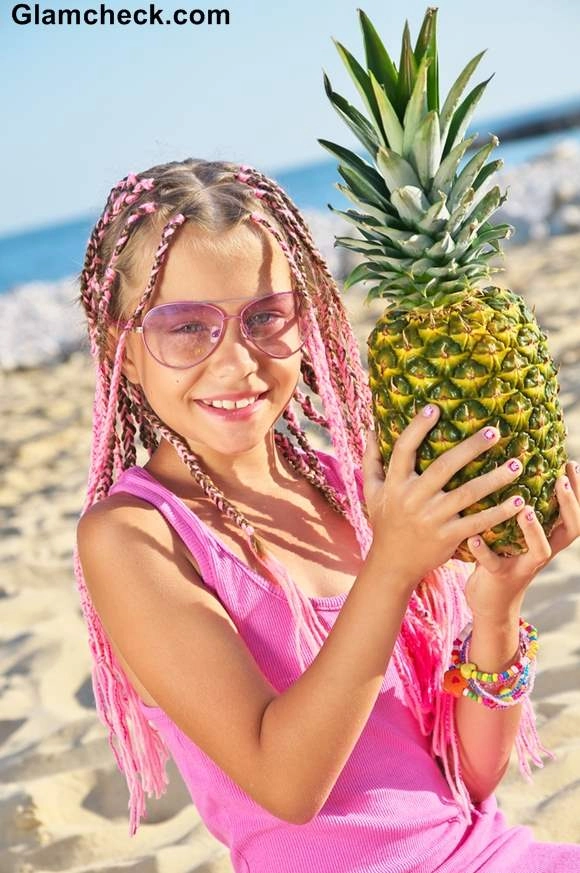 Beach hairstyle for kids: cute braids by the ocean Little girl with beach braids smiling at the shore