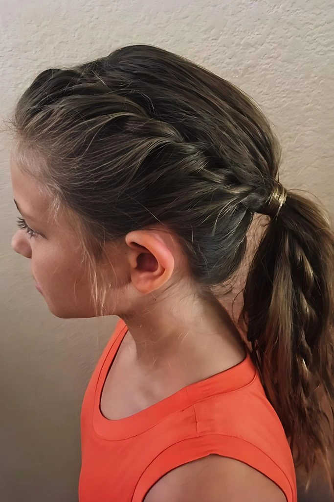 Low beach ponytail with soft waves and loose face-framing strands