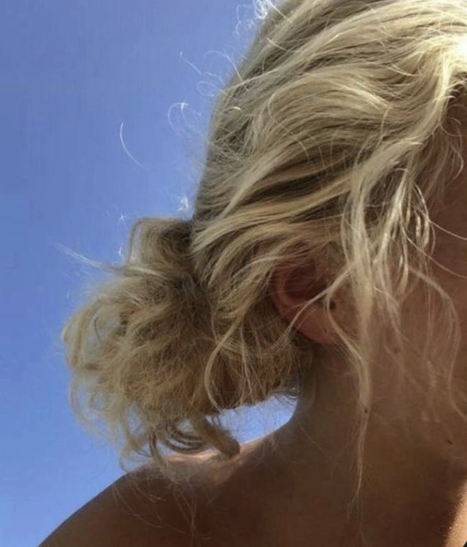 Messy beach bun with wavy hair and sea spray